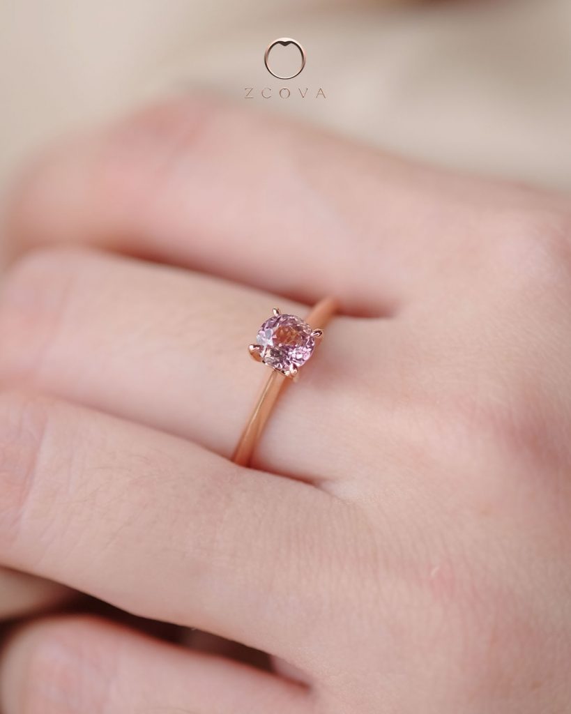 Round-cut brownish pink sapphire with simple 4 prong solitaire setting in rose gold