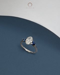 Oval Diamond with Pear-shaped Blue Sapphire Side Stone Three Stone Setting Design White Gold