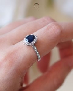 Oval blue sapphire gemstone engagement ring with floral diamond halo